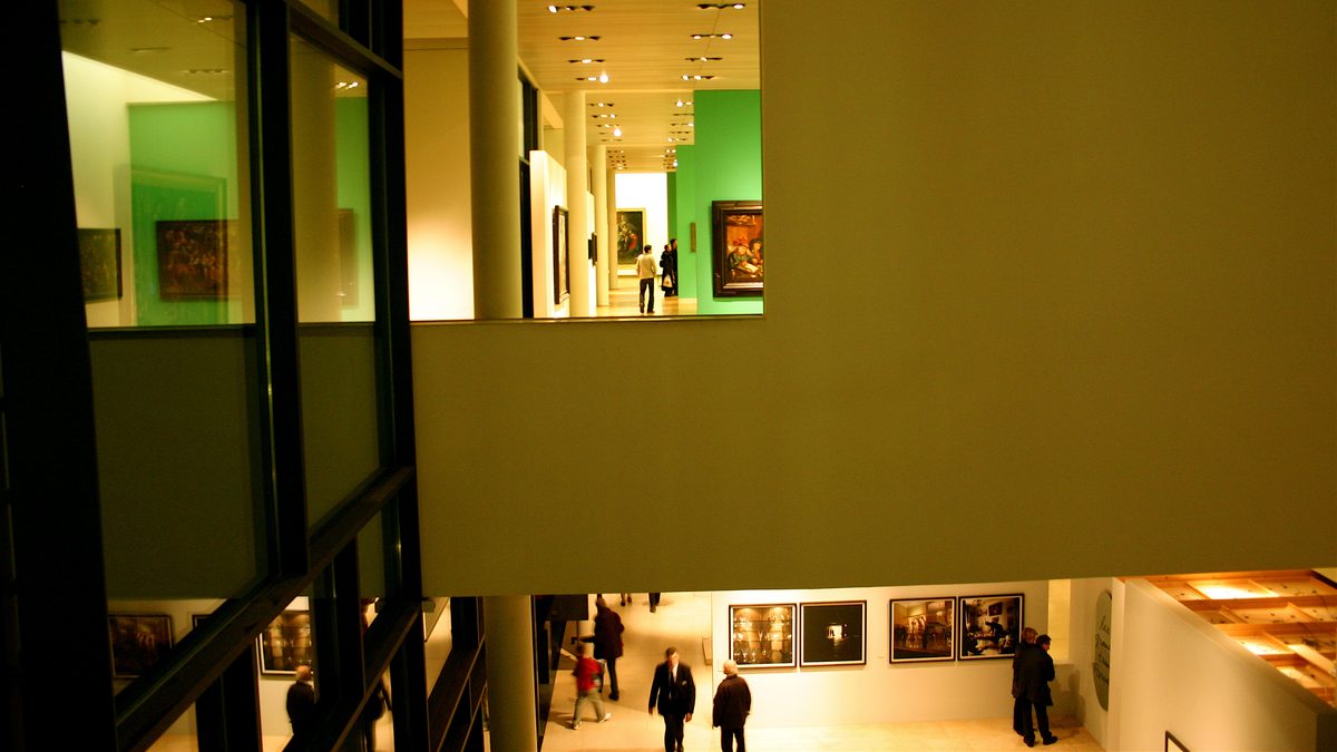 The galleries of the Nancy fine arts museum seen from above, paintings on green walls, visitors below.